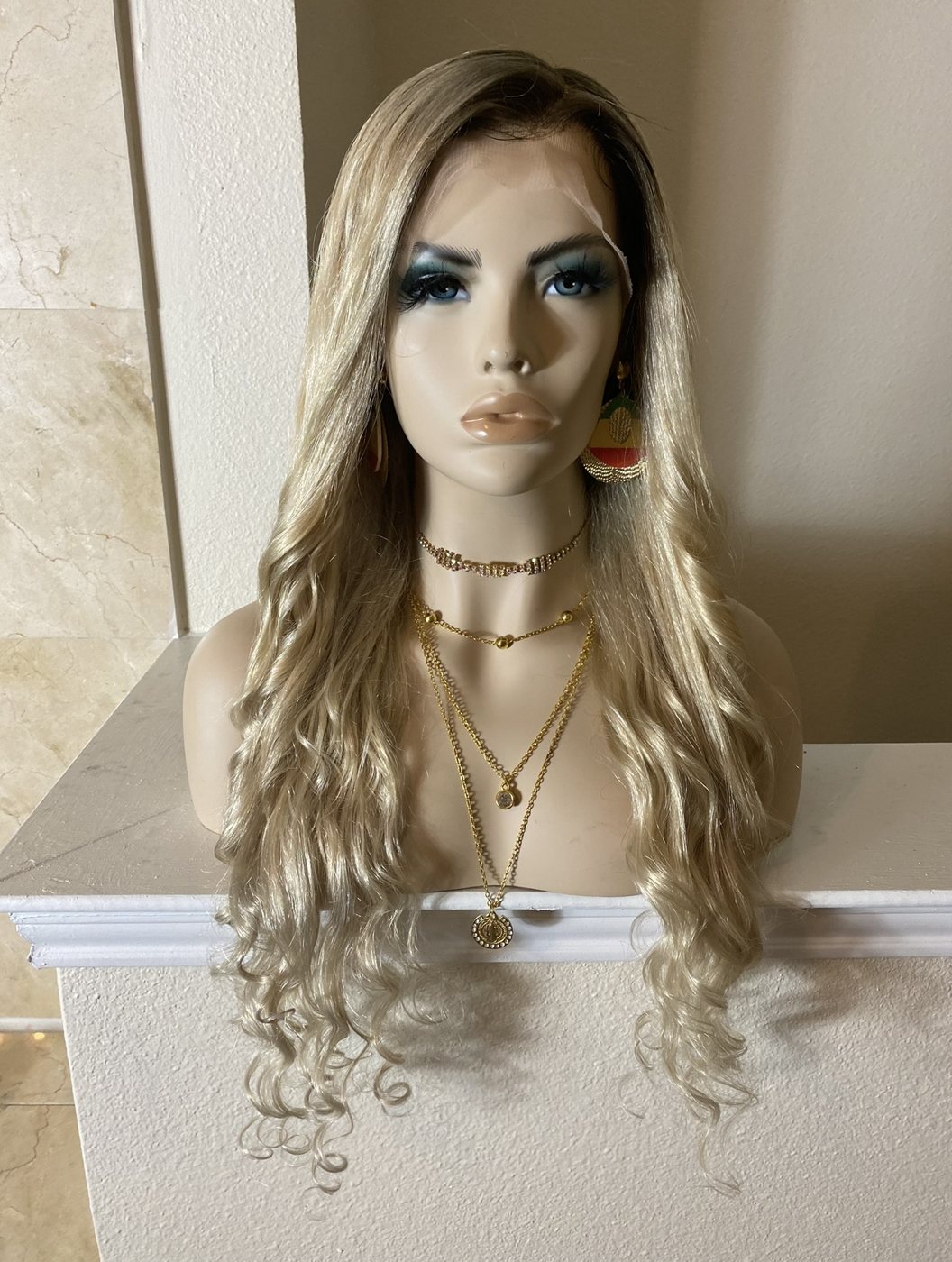 Honey blonde wavy lace wig styled on a mannequin